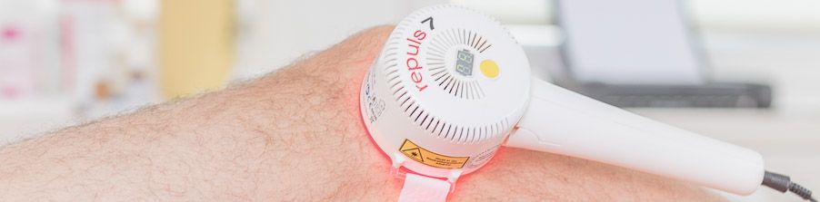 REPULS-Lichttherapiegerät mit rotem Licht am Arm eines Patienten