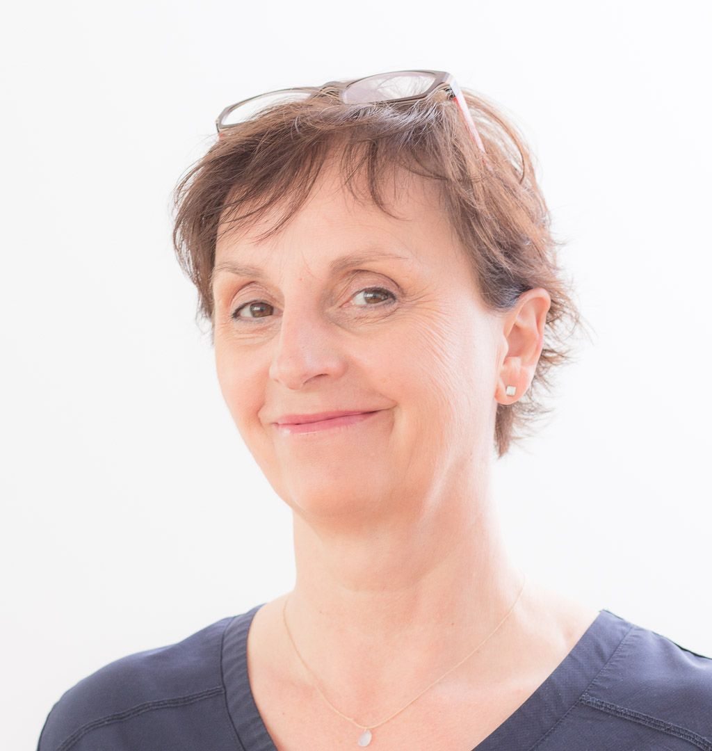 Porträt von Dr.in Karin Moser-Schwab, Fachärztin für Orthopädie, lächelnd vor hellem Hintergrund