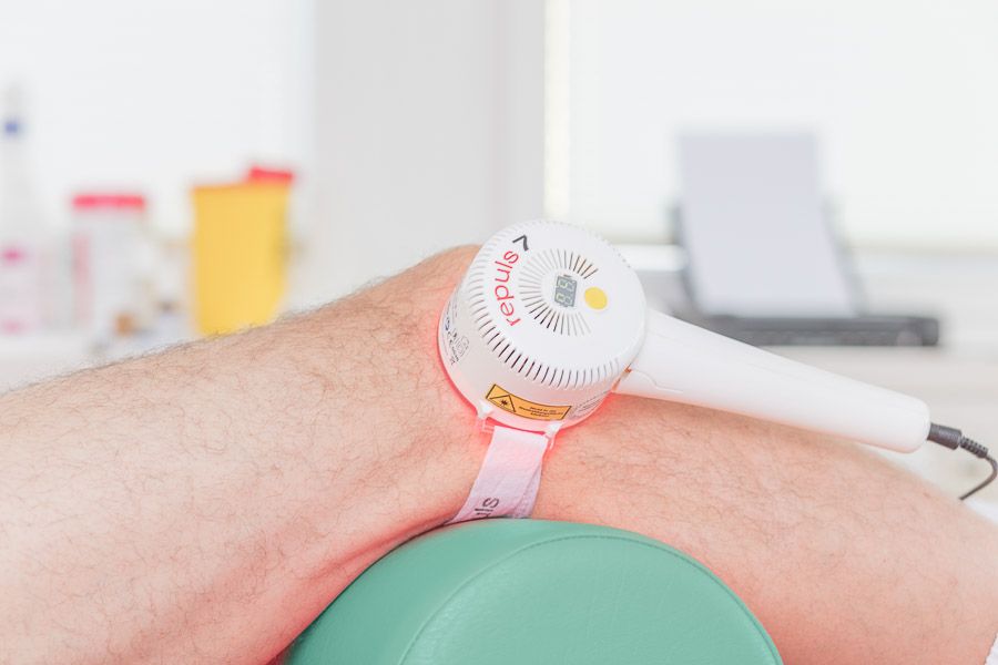 REPULS-Lichttherapiegerät wird am Ellenbogen eines Patienten angelegt