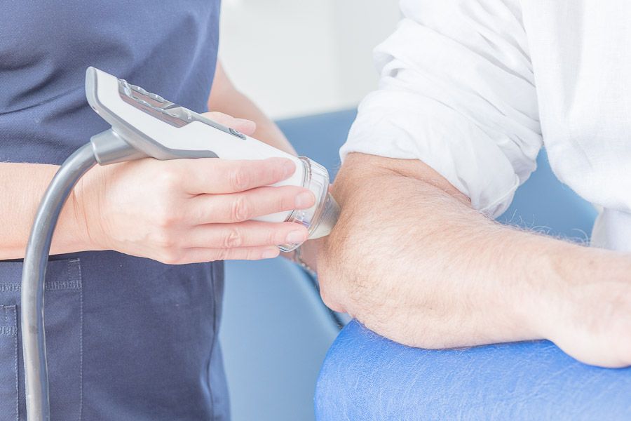 Behandlung der Ferse mit dem Handstück eines Stoßwellengeräts